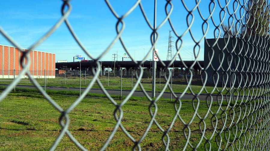 Chain-link fence preventing access to an area of mown grass.